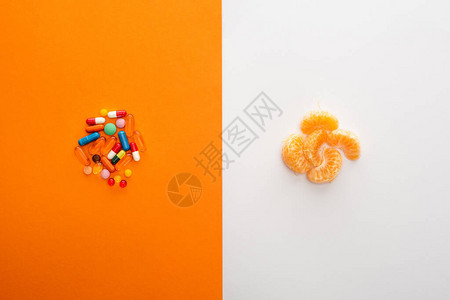 白色和橙色的彩色药丸和普通话的顶部视图图片