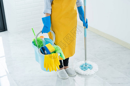 青年女管家或拖把清洁地板上洗衣的清扫站图片