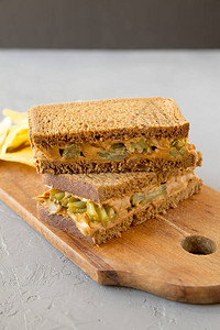 土生长的花生果酱小菜三明治上面有土豆薯片在灰色图片