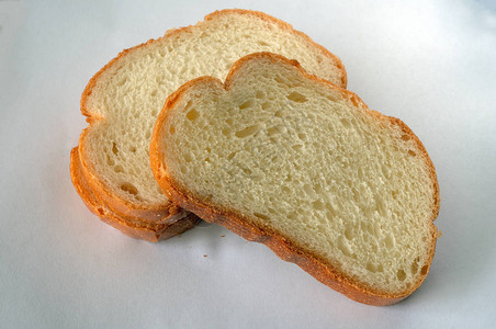 切片面包面包生产新鲜的面包浅色背景上的切片面包店烘烤食物金色切片新鲜食品我们的生产背景图片