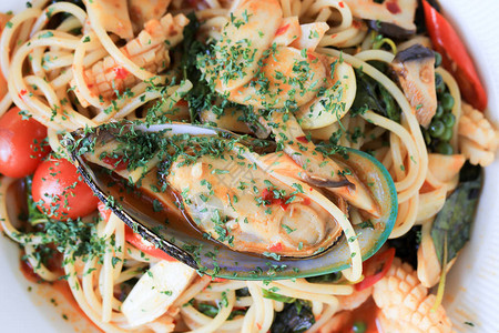 海鲜辣意粉配扇贝鱿鱼虾和罗勒在白盘中著名的意大利菜使用图片