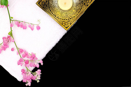 白色棉毛巾粉红葡萄花枝蜡烛和黑色背景的花饰图片