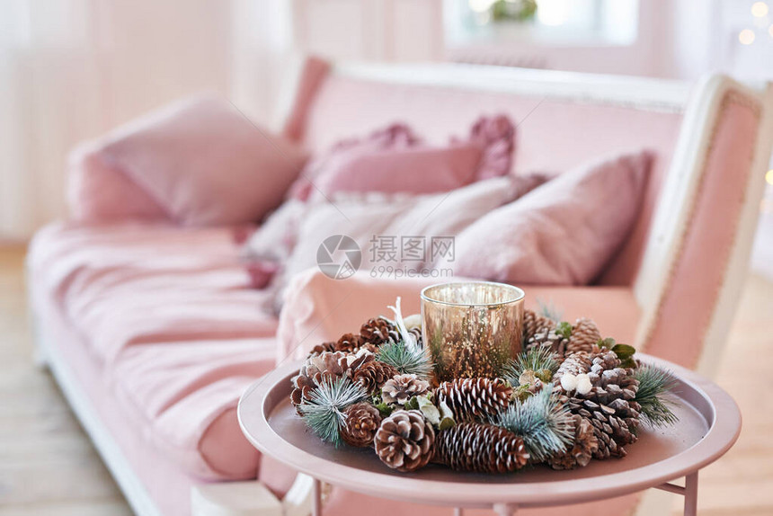 豪华客厅内部配有沙发装饰别致的圣诞树礼物和枕头粉红色调的经典内饰圣诞节在家圣诞树背景上的粉红色沙发图片