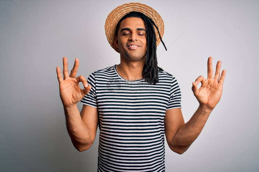 身穿T恤放松帽子满眼笑容闭着眼睛用手指做冥想手势的年轻非洲男子Yega概图片