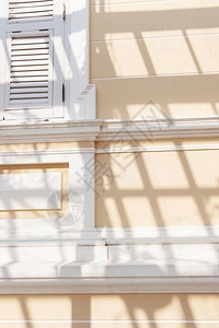 殖民式的住宅建筑外观有条纹阴影殖民奶油墙和阳光图片