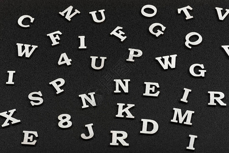 黑色背景上的拉丁字母随机放置字母的图片