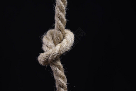 黑色背景上带结的绳索背景图片