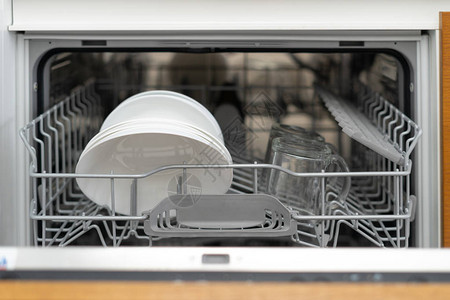 在厨房用白色盘子干净杯子和洗碗机开着的现代洗碗机内建图片