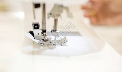 特写女裁缝与纫机一起工作职业女手在缝纫机上用纱线进行缝纫工作图片
