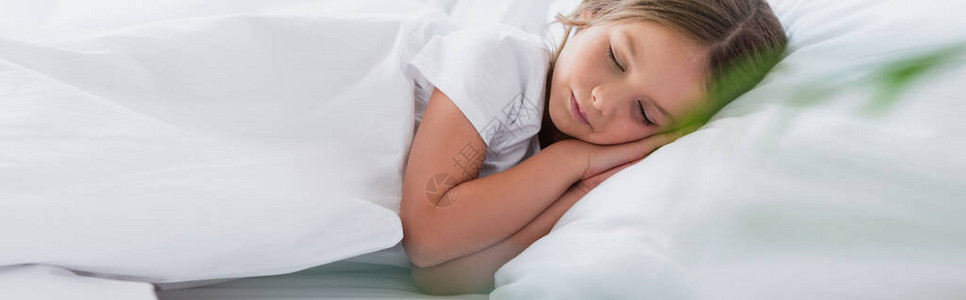 女孩躺在白床上睡觉时睡觉的图片