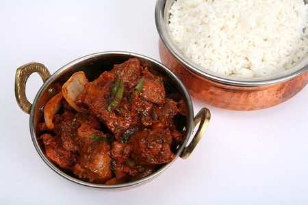 一个印度小碗里面装着辣椒咖喱牛肉后面图片