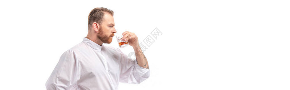 苏格兰红发男子喝威士忌从玻璃杯中饮酒孤立在白色图片