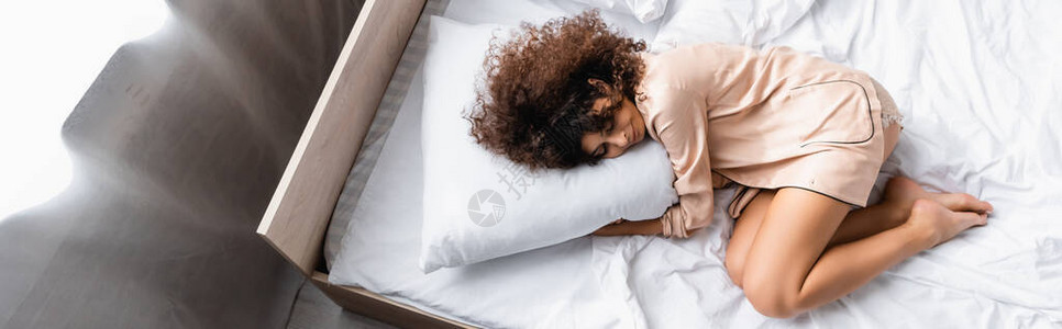 赤脚妇女睡在床上时闭着眼睛枕头的图片