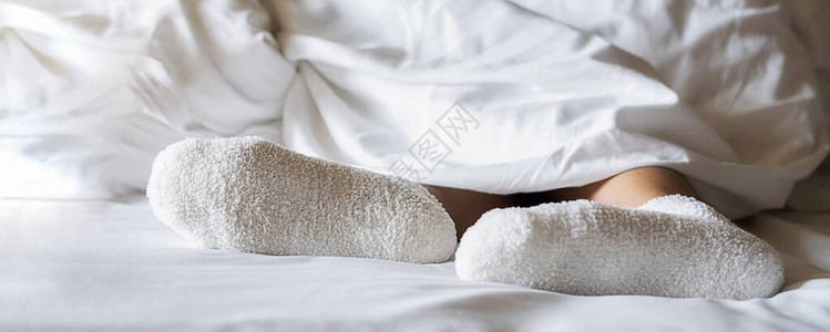 身穿温暖羊毛袜的妇女穿着白色床衣图片