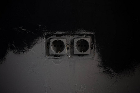 黑色背景上两个电源插座的特写图片