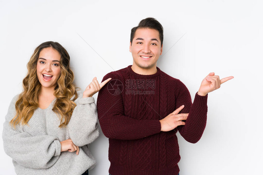 年轻夫妇装扮在白色背景中微笑地着与救图片