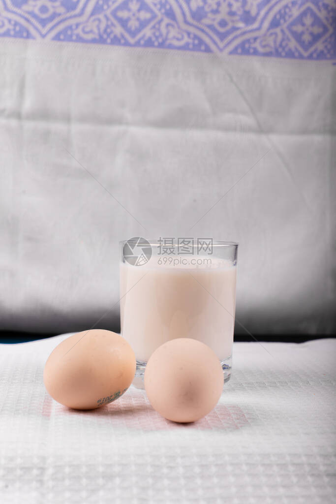 一杯牛奶有生鸡蛋在白图片