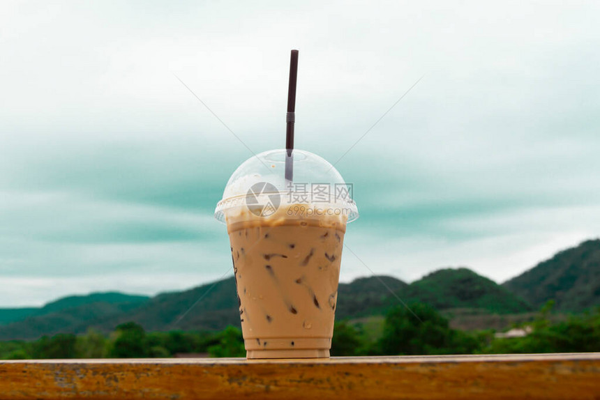 咖啡在玻璃杯里坐在一张长桌子上在山的后面有一个景色图片