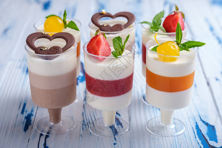 葡萄酒杯装饰巧克力草莓薄荷和鸡尾酒樱桃中的六层慕斯甜点图片