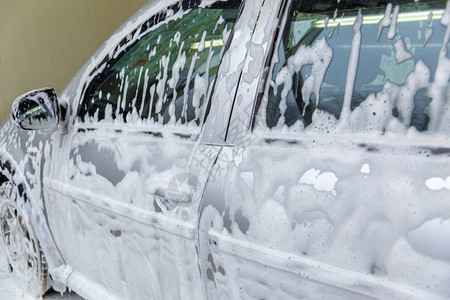 在室内清洗时被肥皂泡沫覆盖的汽车以有选图片