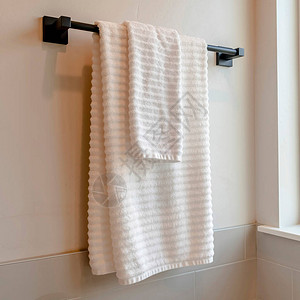 方形裁剪黑色杆与白色毛巾安装在浴室墙上的瓷砖图片