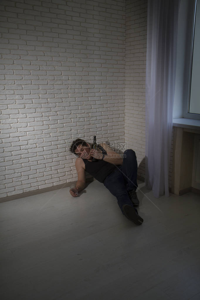 一个邋遢的男人躺在房间的角落里睡觉图片