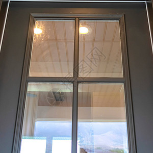 Wooden家门前有反映户外风景的玻璃窗图片