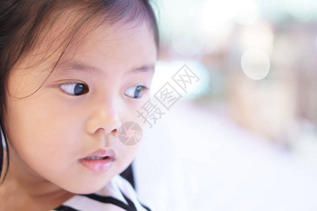 坐在清晰玻璃窗上等待的亚洲儿童可爱或小女孩的近身脸孔图片