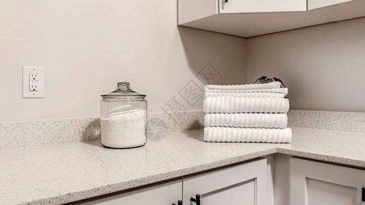 全景框架台面与一罐粉末洗涤剂和折叠毛巾放在木柜上悬挂式储物柜和电源插图片