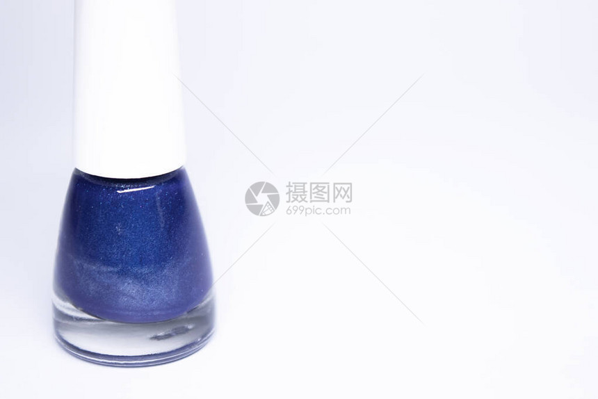 一瓶白色背景上的蓝色指甲油指甲油指甲修指甲概念隔图片