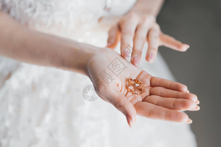 握着棕榈上的金婚戒指的新娘之手结婚和姻的概图片