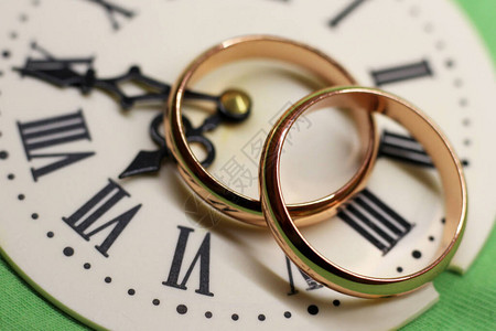 两个结婚戒指和一张手表罗马背景图片