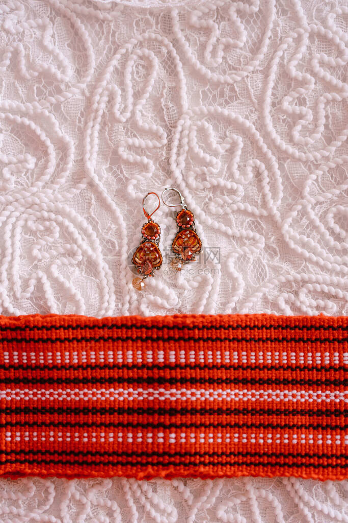 白蕾丝织物上用石块和橙色条纹在白图片