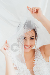 新娘在婚纱中有选择地聚焦于戴面纱和看白布图片