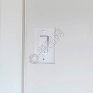 方形框架安装在白墙背景上的家用室内电灯开关带有扁平宽杆的翘板开关由两个螺背景图片
