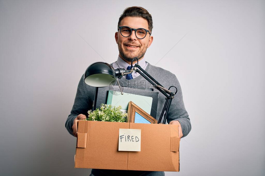 蓝眼睛的年轻商人拿着箱子从办公室被解雇图片