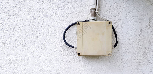 将信号电缆或电话线路与安装在石水泥墙上左复印空间的输管连接起来的图片