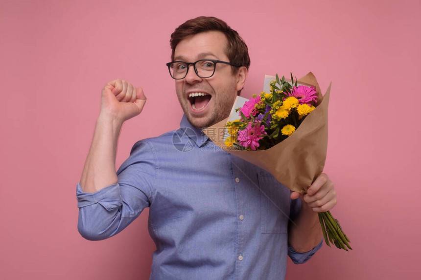 戴眼镜的年轻天主教青年男子用鲜花给女朋友送生日礼物图片