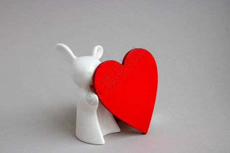 白色背景的美丽的陶瓷兔子红色心脏的白兔雕像图片