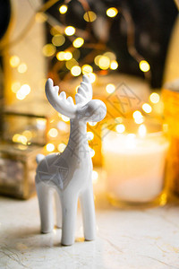 小白色陶瓷圣诞鹿雕像黄色的假日灯光和冬图片