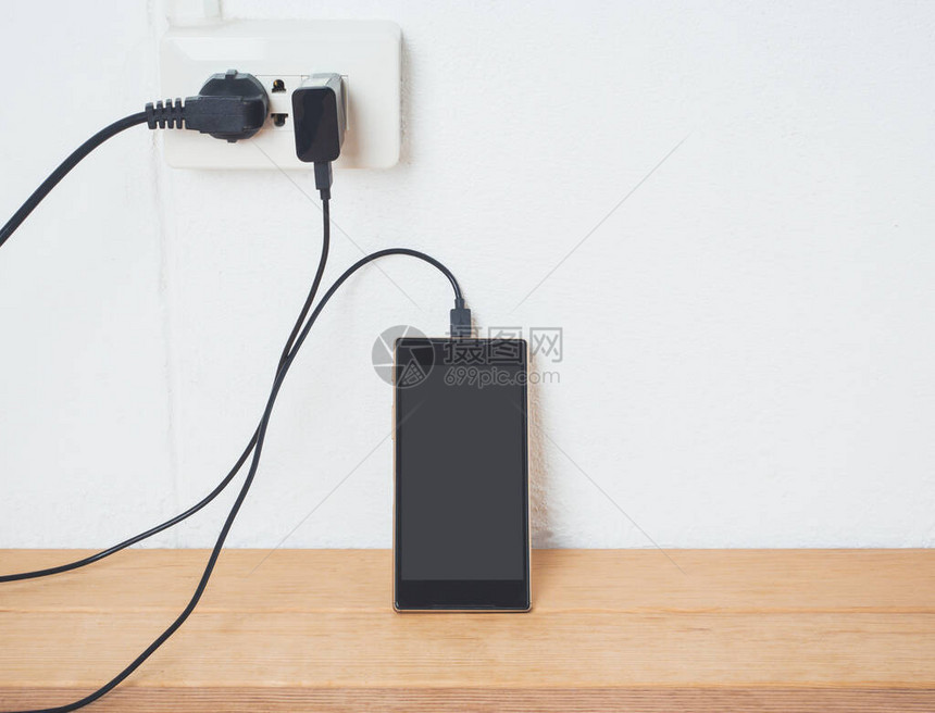电荷充电中的移动电话插在白墙上低电图片