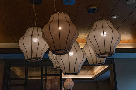 客厅里的灯天花板下挂着几何形状灯罩的复古灯的特写传统的米色织物表面图片