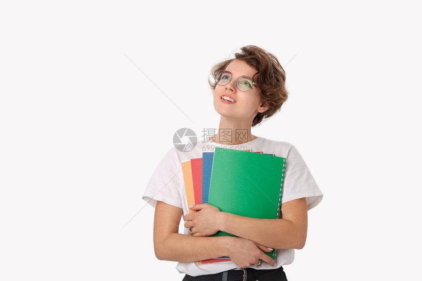 穿着白衬衫和眼镜的微笑的年轻女学生拿着五颜六色的文件夹图片