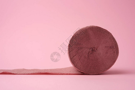 粉红色背景上未扭曲的粉红色卫生纸卷特写图片