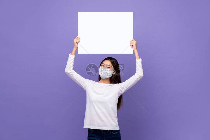 身戴医疗面具的年轻亚洲妇女带着白纸板图片
