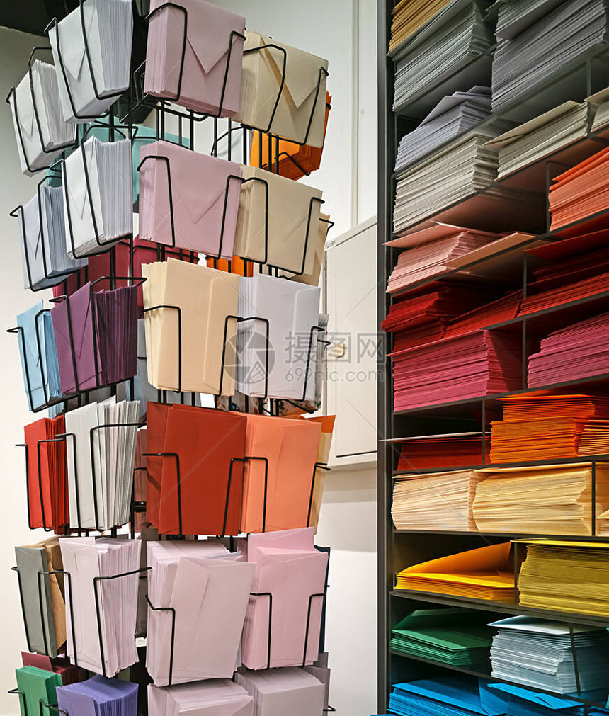商店货架上的不同颜色和尺寸的信封文具和艺术品商店分类的信封和纸图片