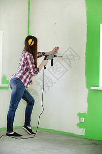 建造者在公寓里修理完成抹灰和墙壁粉刷的工作大师与油漆钻图片