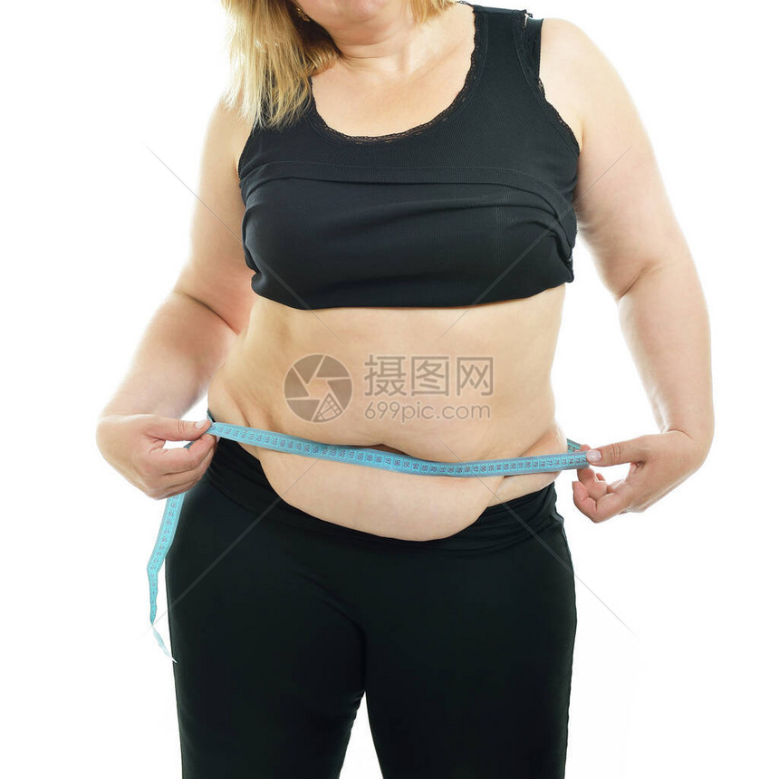 超重不快乐的年轻女测量腰部图片