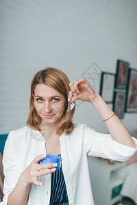 身着白袍的年轻女子手握着化妆眼罩图片