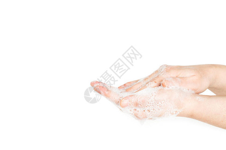 妇女用白背景的肥皂泡沫洗手图片